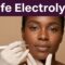 A Black woman receives gentle facial electrolysis from a gloved electrologist.