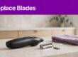 A body groomer and worn blade rest on a bathroom counter beneath a purple “Replace Blades” banner.